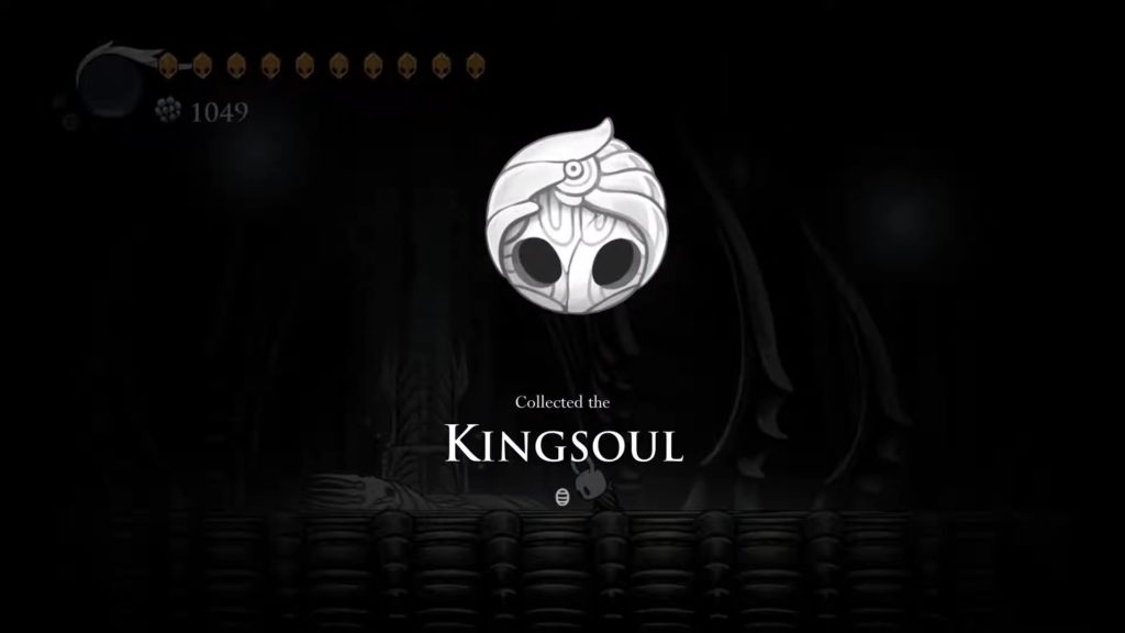 Collecting the Kingsoul charm in Hollow Knight.