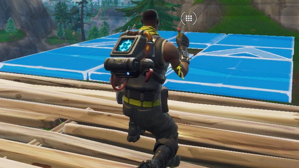 Fortnite character crouching while building a wooden platform.