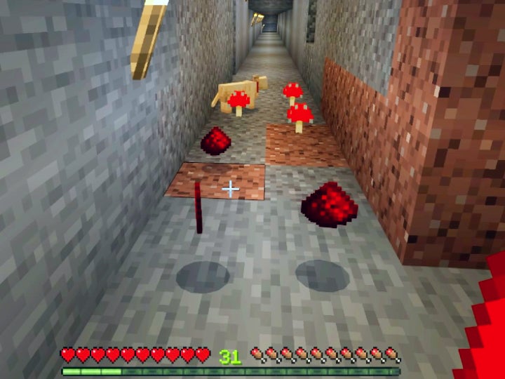 A few pieces of redstone dust in a stone and granite corridor underground.