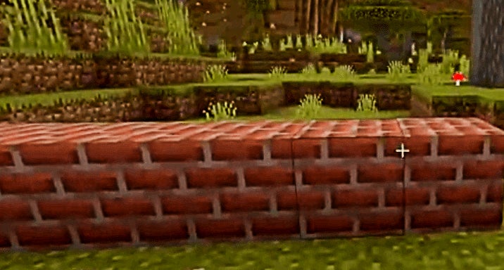 Multiple bricks blocks in a line on some grass.