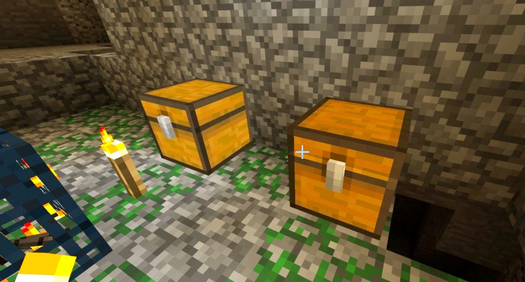 The player finding 2 small yellow chests next to a monster spawner in a dungeon with mossy stone blocks under them.