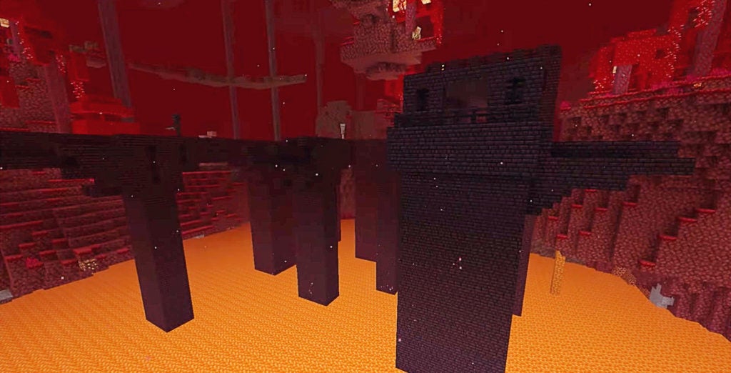 Dark red nether brick columns and bridges that are over a lake of orange lava.
