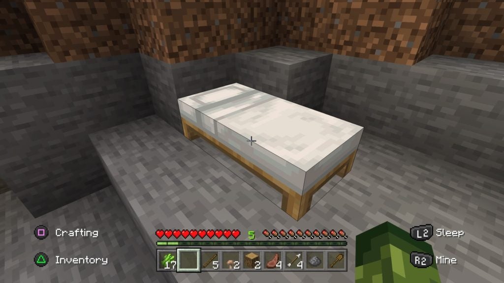The player looking at a white bed placed on the stone floor.