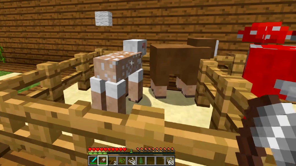 A player shearing a white sheap for its wool. There is a brown sheep nearby.