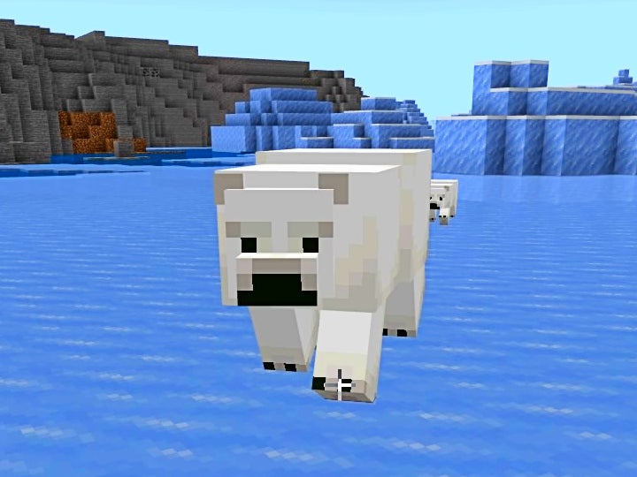 Close up of an adult polar bear with a polar bear cub behind them.
