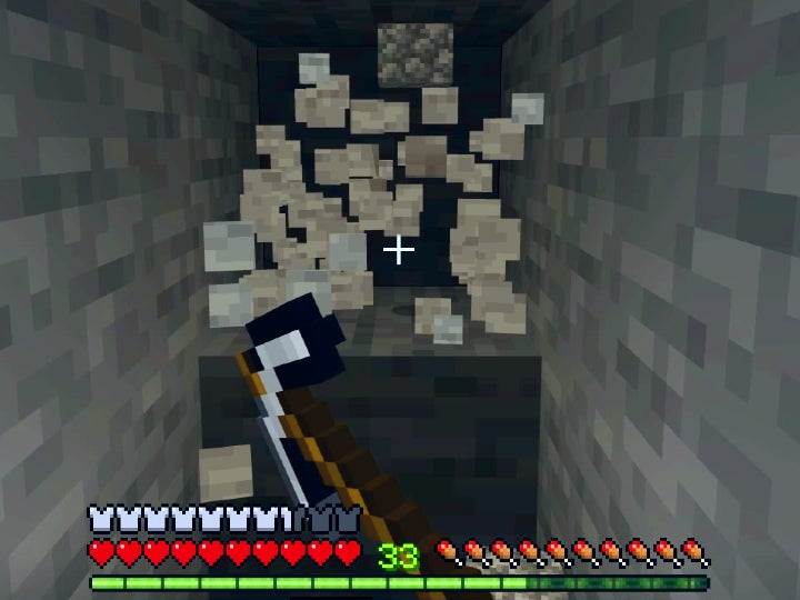 The player breaking a stone block with an iron pickaxe.