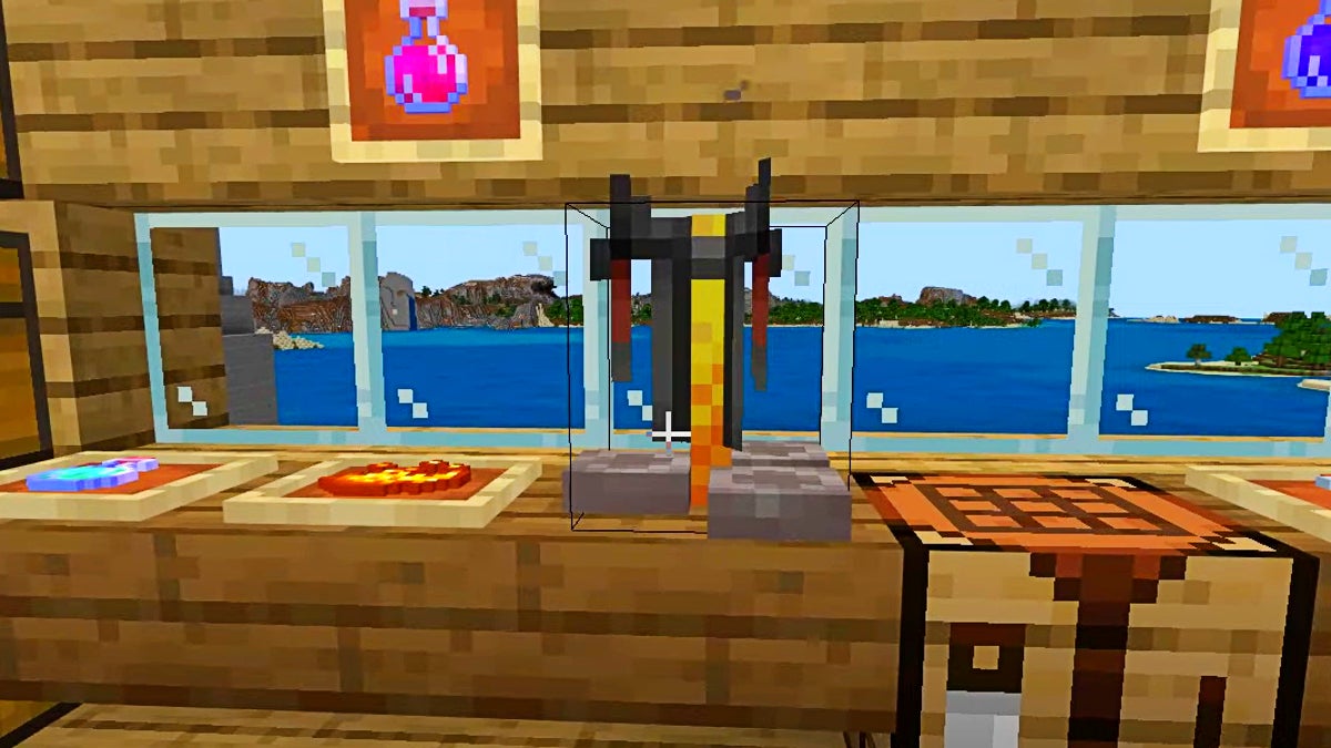 A yellow and black brewing stand on a table next to a crafting table. It is in front of some glass pane windows.