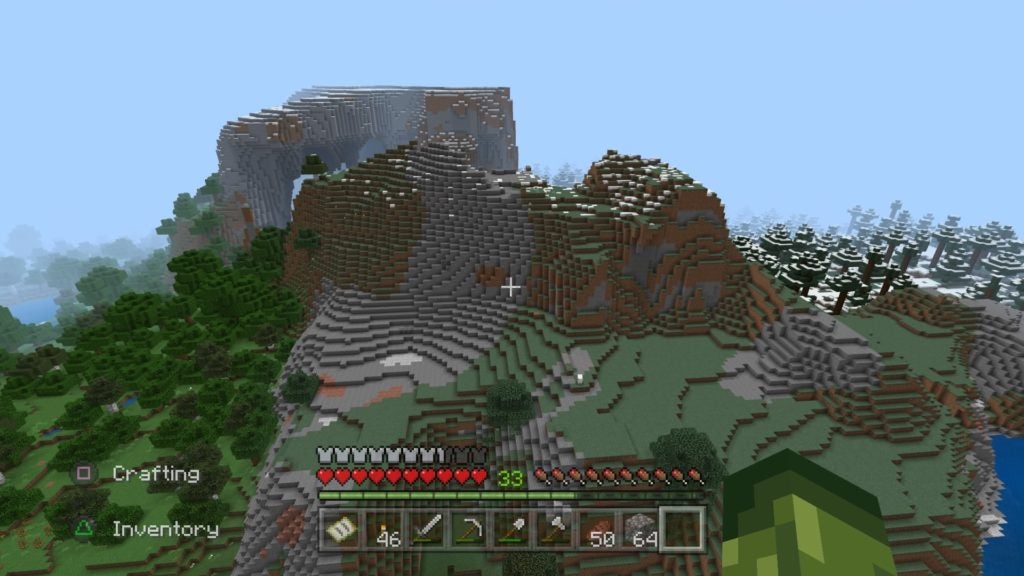 The player from an elevated position looking at a series of large hills. The hills are mostly made of stone and dirt blocks.
