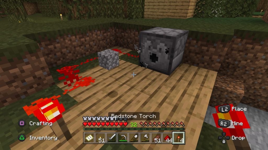 A dispenser powered in a redstone circuit dropping a block of cobblestone as an item. The list of redstone dust and the redstone torch are glowing brightly.