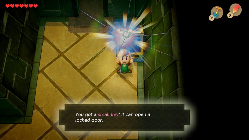 Link holding up a small key that he found in a chest.