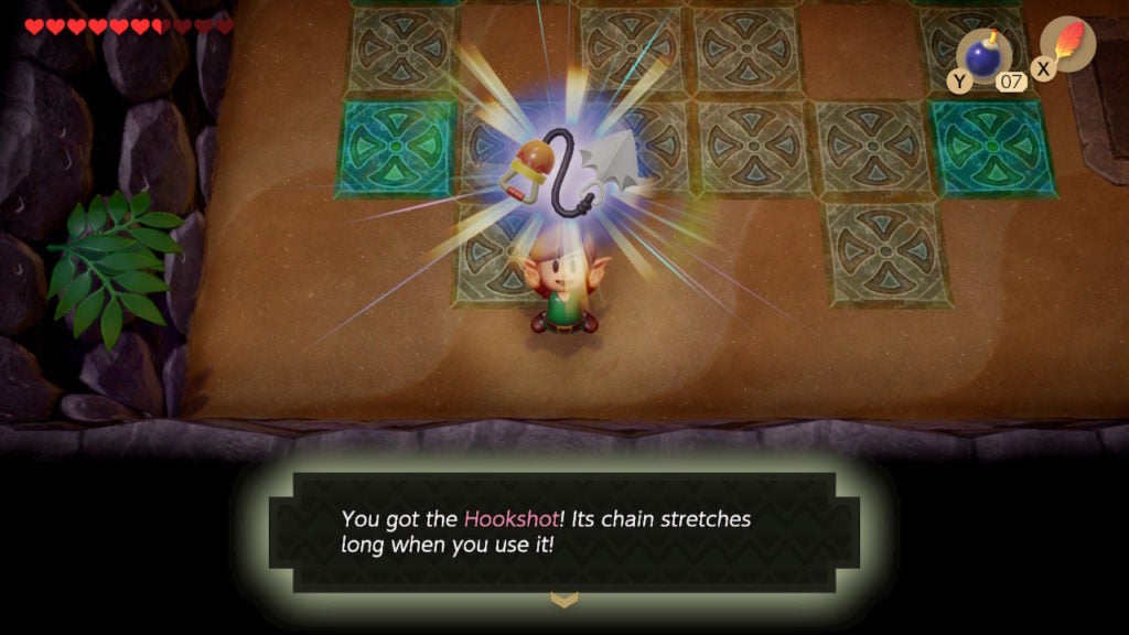 Link holding up the Hookshot, which is a grappling hook with a handle.