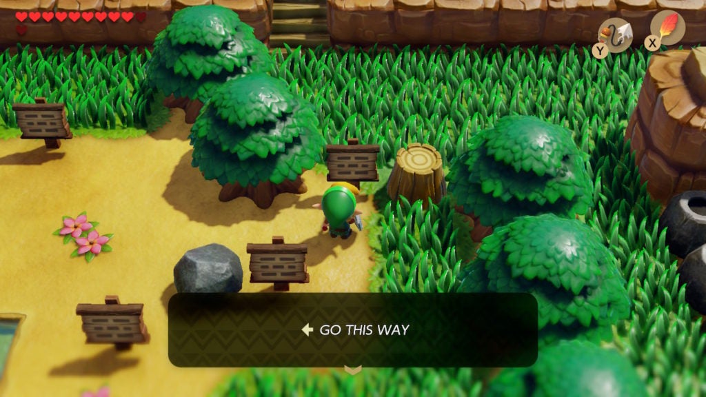 A signpost in the very northeast corner just west of a tree stump. It directs the player west.