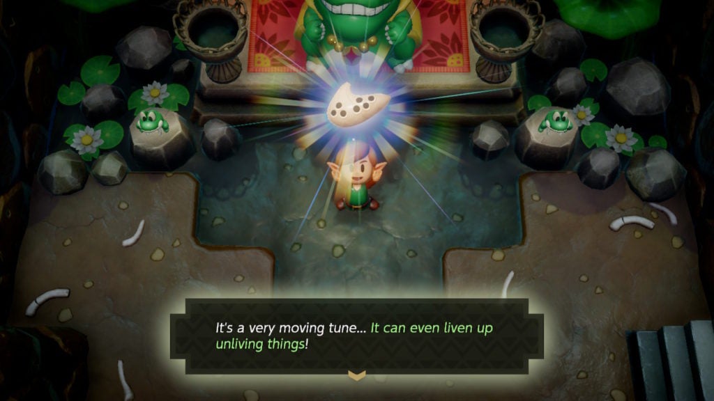 Link holding up the Ocarina after learning the Frog's Song of Soul from Mamu, who is standing nearby. The text at the bottom mentions that the song can be used to liven up unliving things.