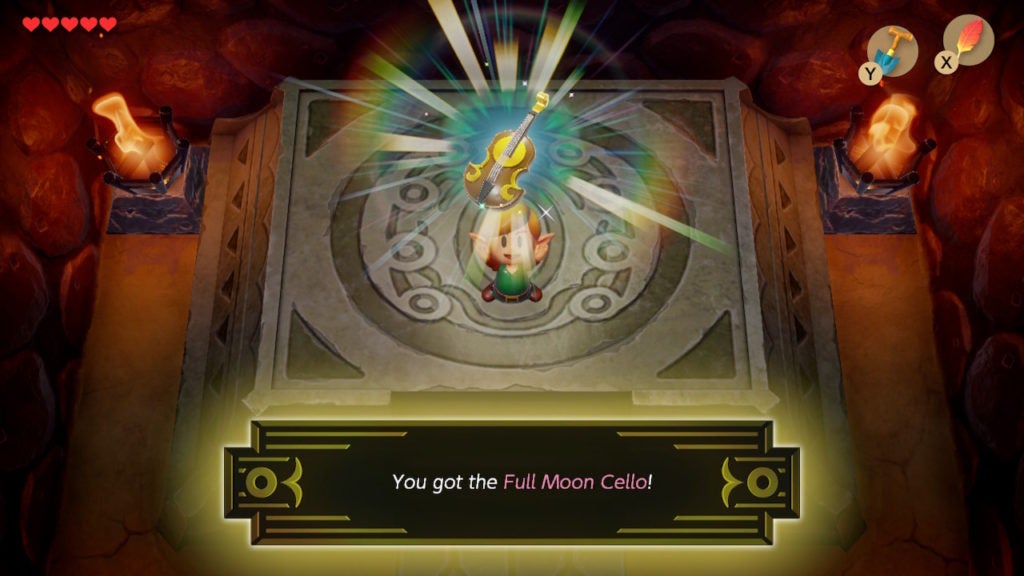 Link holding up the Full Moon Cello, which is a light brown cello with a full moon on is front surface.