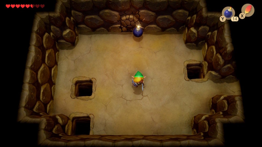 Link placing a bomb at the north wall under the quicksand pit where there are cracks.