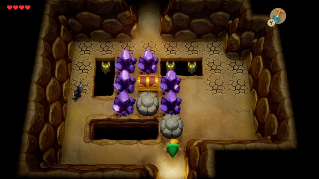 A chest in a cave surrounded by purple crystals and some rocks.