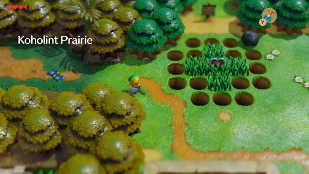 The player entering Koholint Prairie. There is a path leading southeast and a patch of grass with a heart piece surrounded by holes.