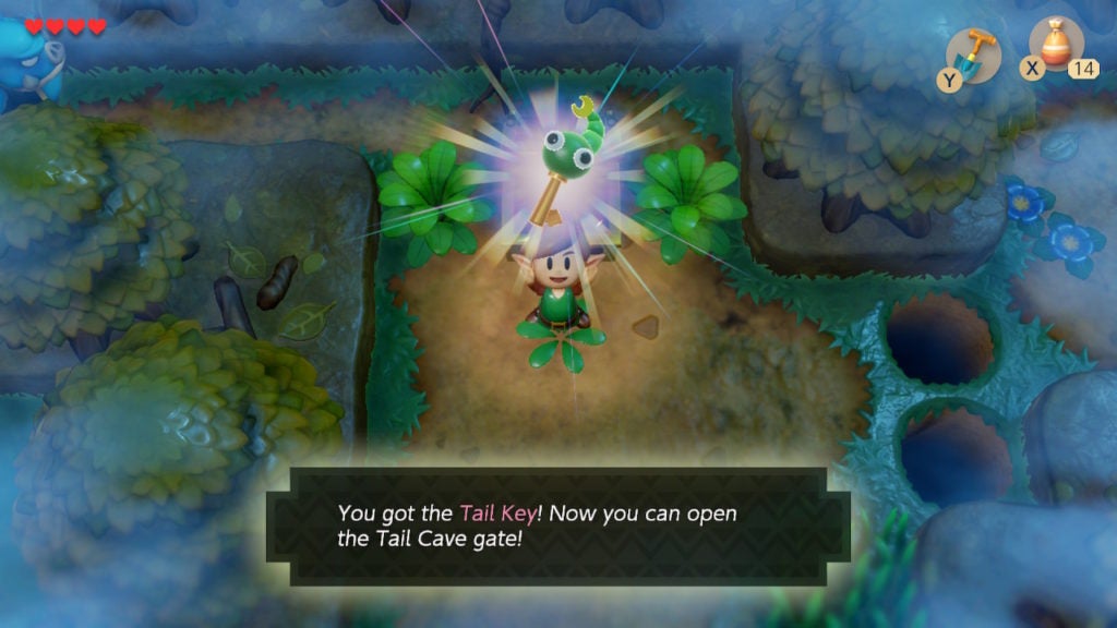 The player looting the Tail Key from a chest. They are holding it above their head excitedly.