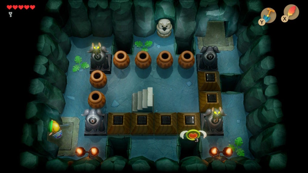 A room with stairs that lead up, though the set of stairs is cut off from the player by by pots and blocks.