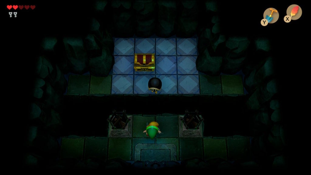 A dark room with a gap in the middle that you need to jump across to reach the chest on the other side.