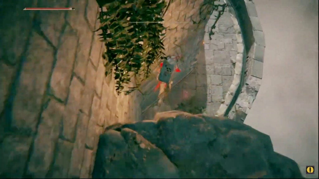 The player jumping from a rocky ledge down to a stone balcony.