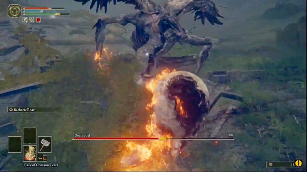 Deathbird, a spindly yet huge avian monster, is getting hit in the head by the player who is swinging a flaming hammer.