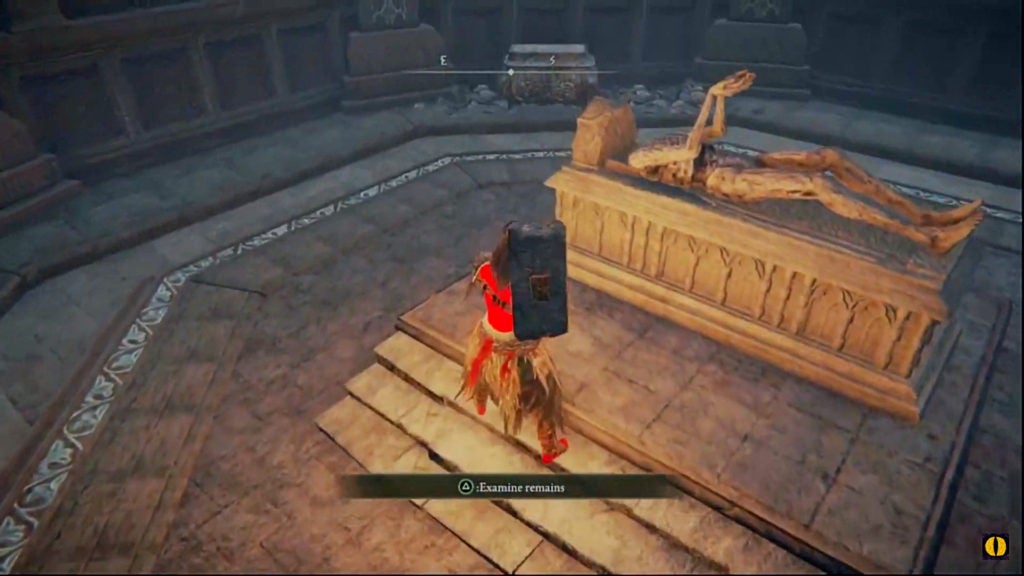 The player looking at a husk-like corpse on a stone slab within a walking mausoleum.
