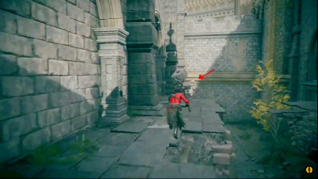 The player on top of the rubble ramp and looking towards an area being pointed at by a red arrow.