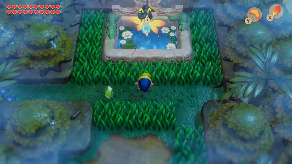 Link about to speak to the Great Fairy in the Mysterious Forest. The large fairy is a humanoid with yellow wings who is hovering above a pond.