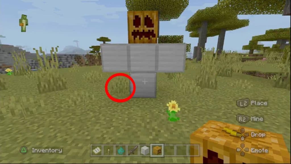 The configuration to make an Iron Golem with a block of grass adjacent to it. The block of grass has a red circle around it.