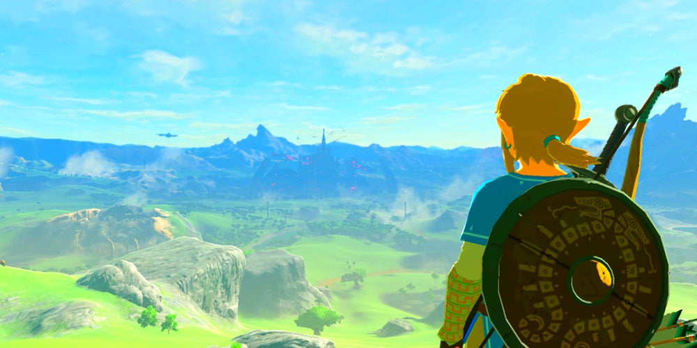A view of Link from behind as he looks down at a green valley.