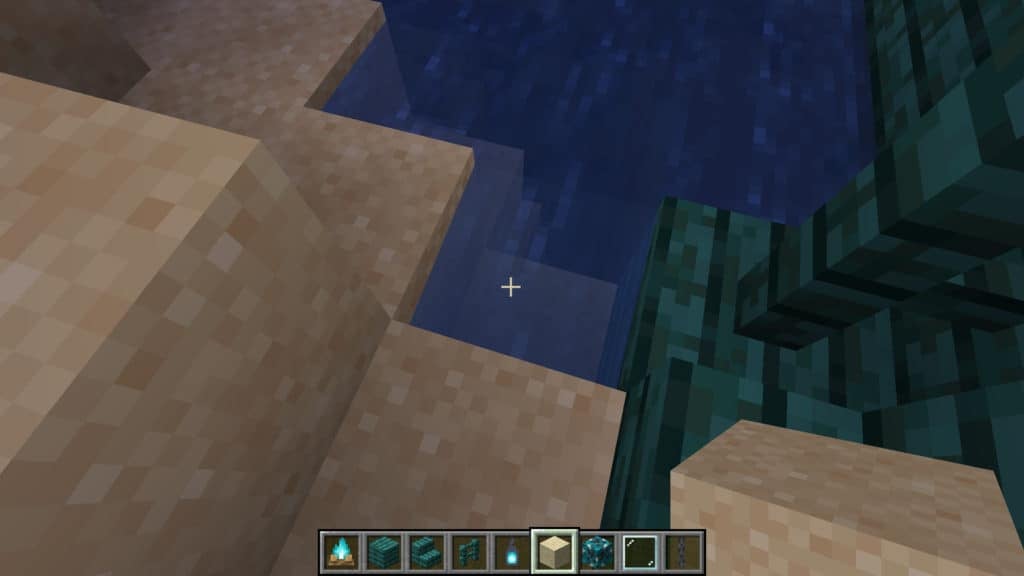 A player about to place a block of sand over some flowing water for aesthetic perfection.