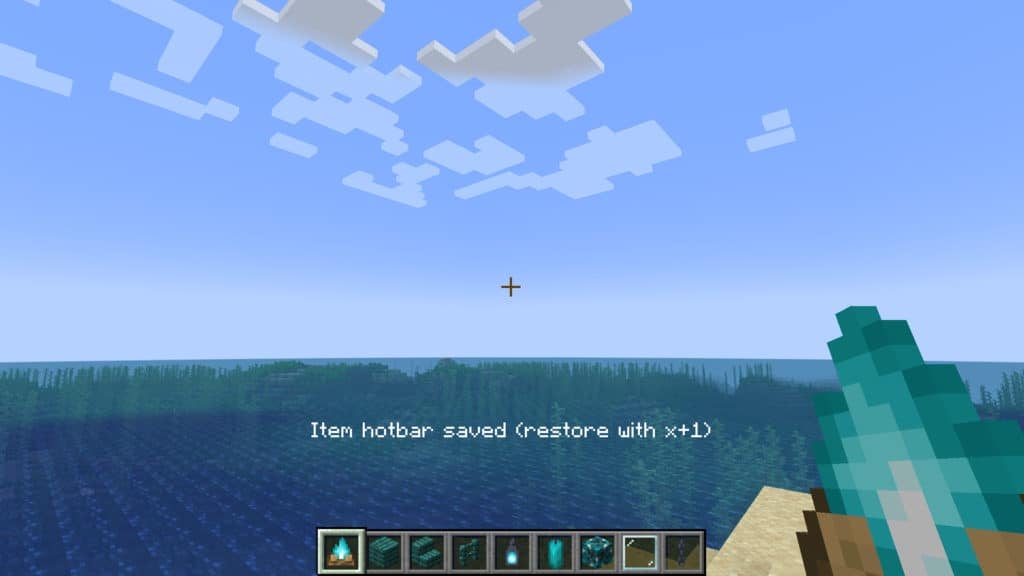 A player with many cyan blocks and objects in their hotbar saving their hotbar layout while a message in white text appears to confirm that they've successfully saved their hotbar and can restore it with X+1.