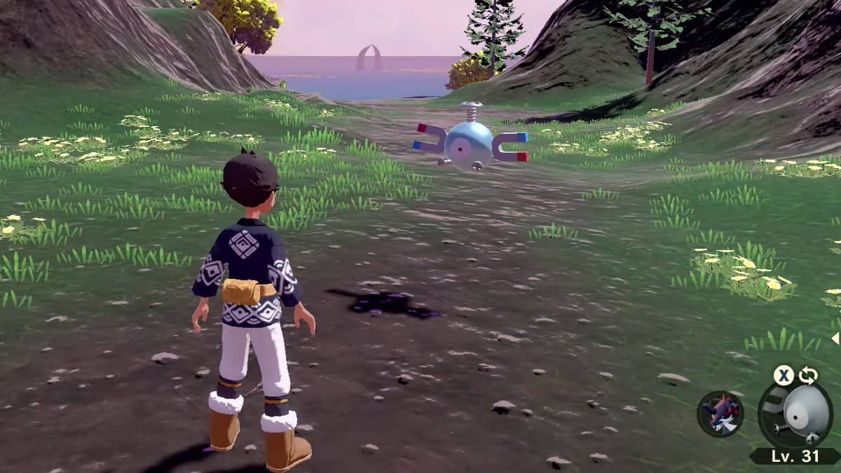 A player standing next to their Magnemite on a dirt path.