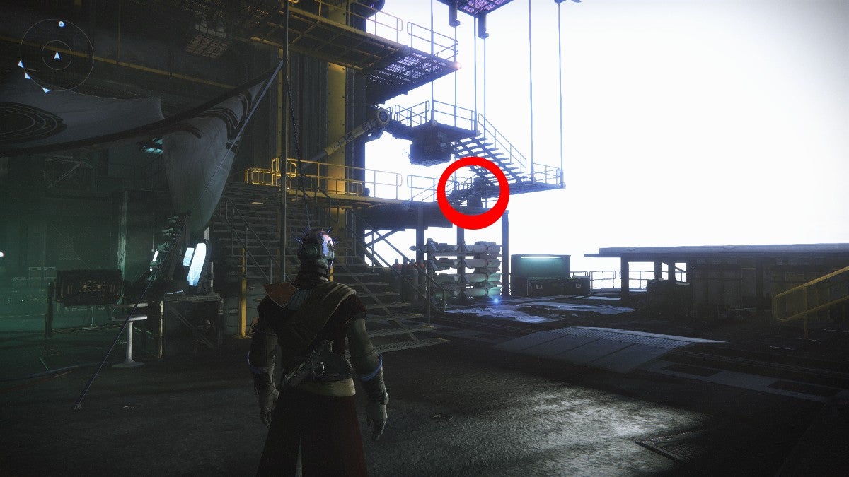 A player looking at the stairs and catwalk in the Hangar and seeing Xur. Xur is outlined in a red circle.