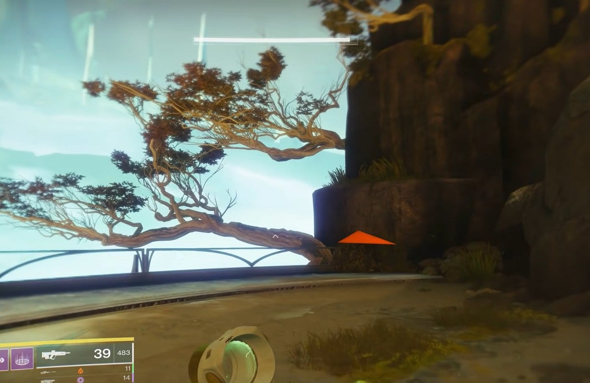 A player looking at some ledge partially obscured by some horizontal trees.