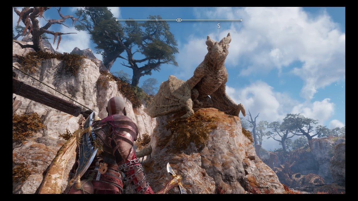 Kratos staring up at a dragon statue.