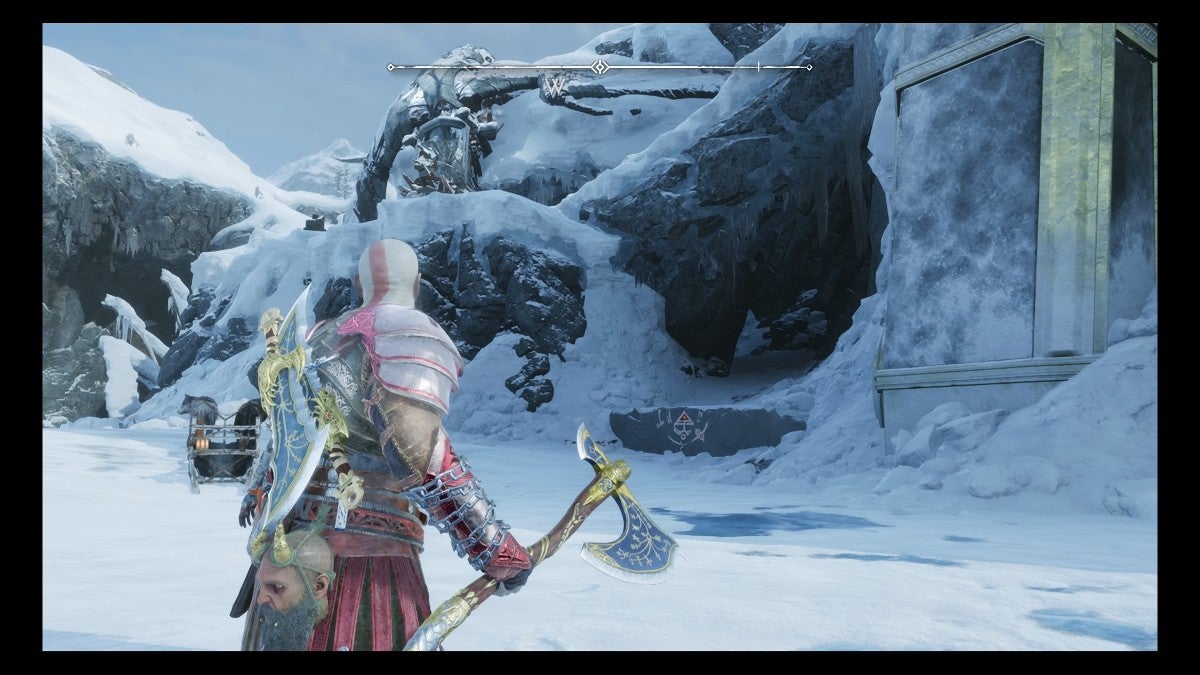 Kratos looking at a ledge that leads into a cave.