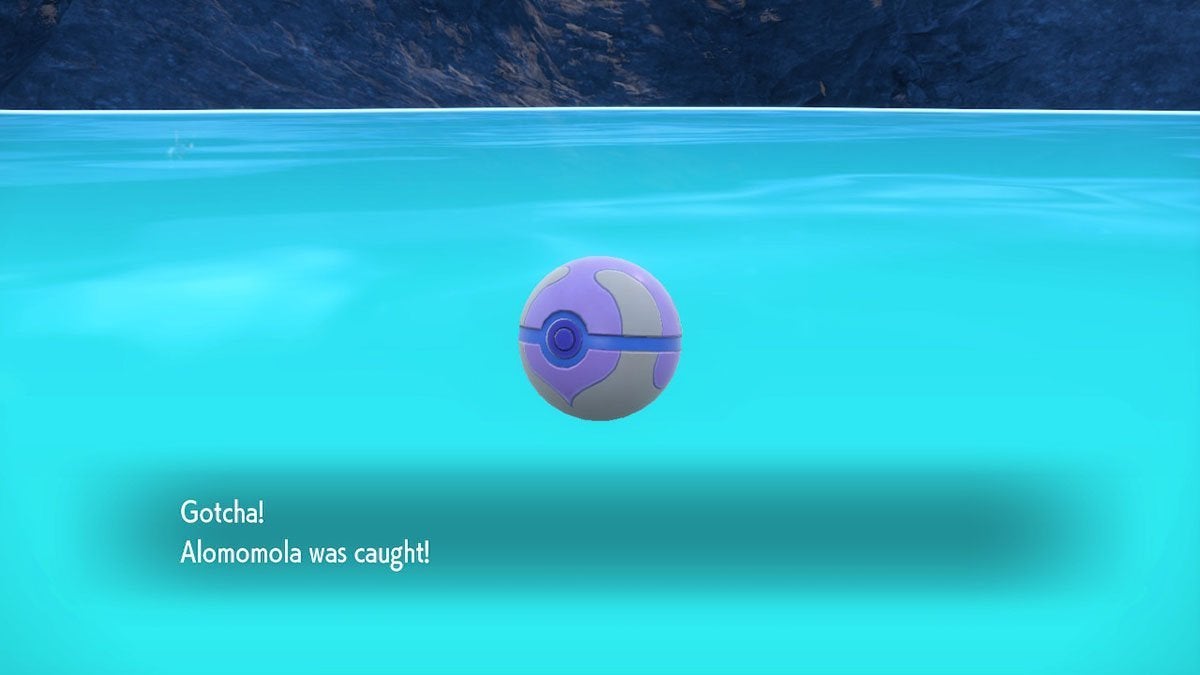 A player catching an Alomomola in a pink Heal Ball.
