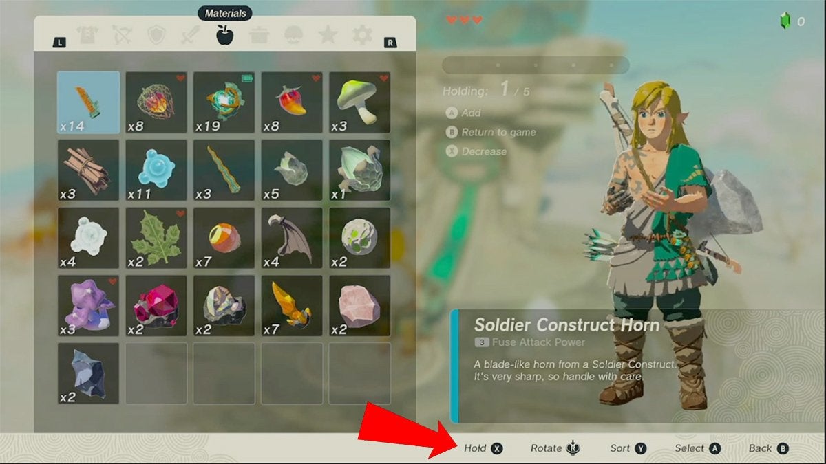 Link holding inventory items in his hands while a red arrow point to the button used to hold items.
