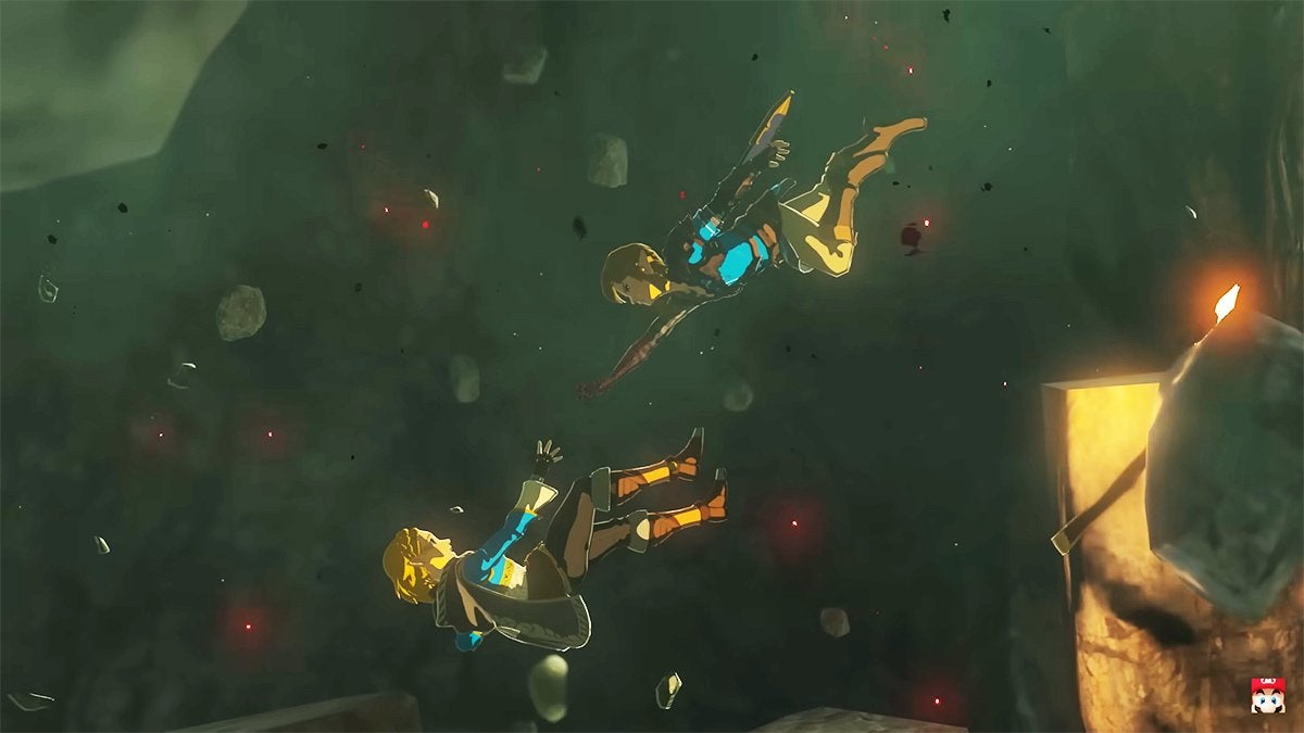 Zelda falling into a fissure in the ground while Link tries to save her in a Tears of the Kingdom trailer.