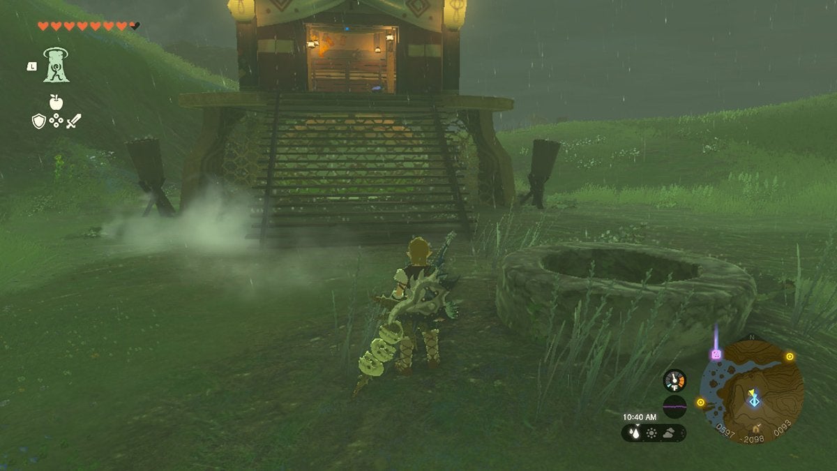 Link standing near a well and a tower.