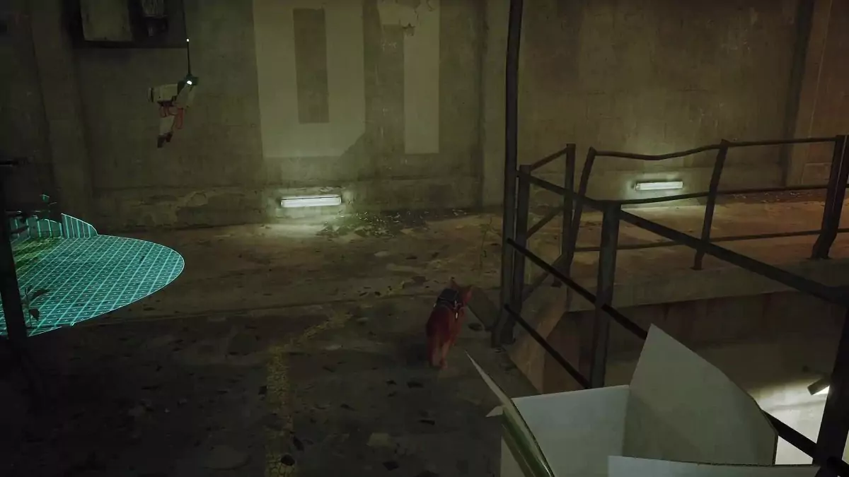 The Stray cat in the Neco factory next to a metal railing.