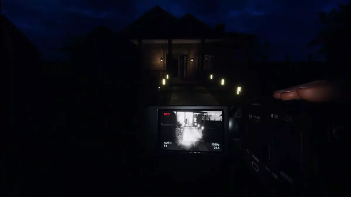 Recording a dark house using a video camera in Phasmophobia.