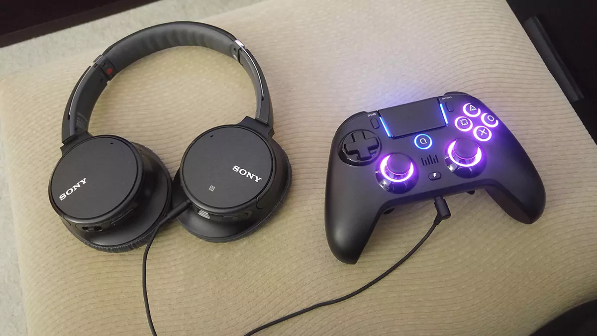 A pair of Sony over-the-ear headphones plugged into a Spark N5 controller for PS4.