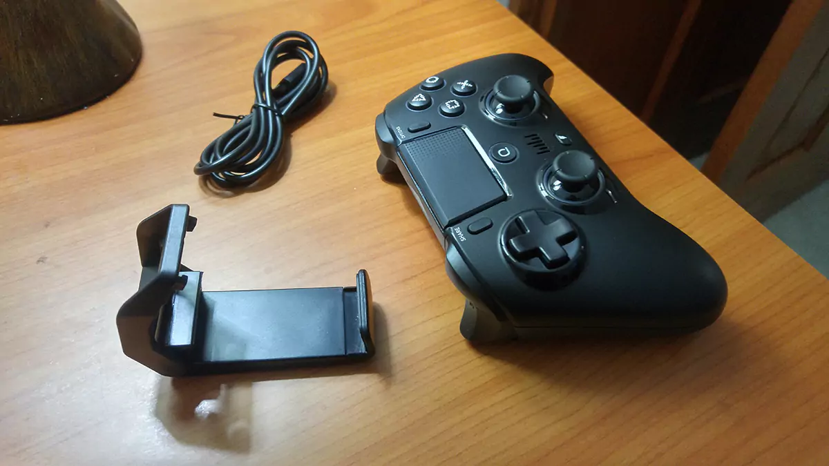 A Spark N5 controller nest to its charging cable and a piece of plastic that lets its owner rest it on its back.