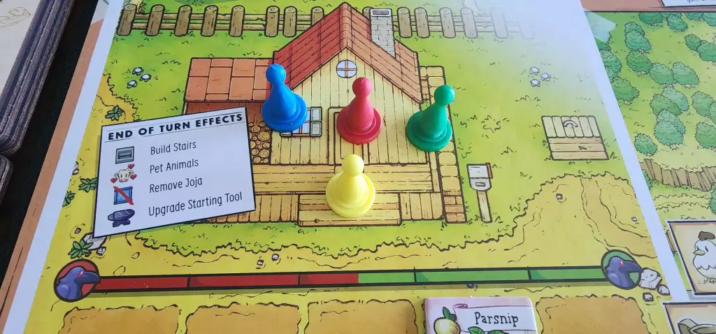 The player pieces in the Stardew Valley board game along with the End of Turn goals.