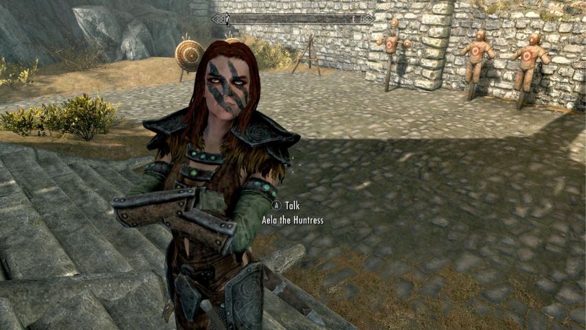 Aela the Huntress from Skyrim looking at the player behind Jorrvaskr in Whiterun