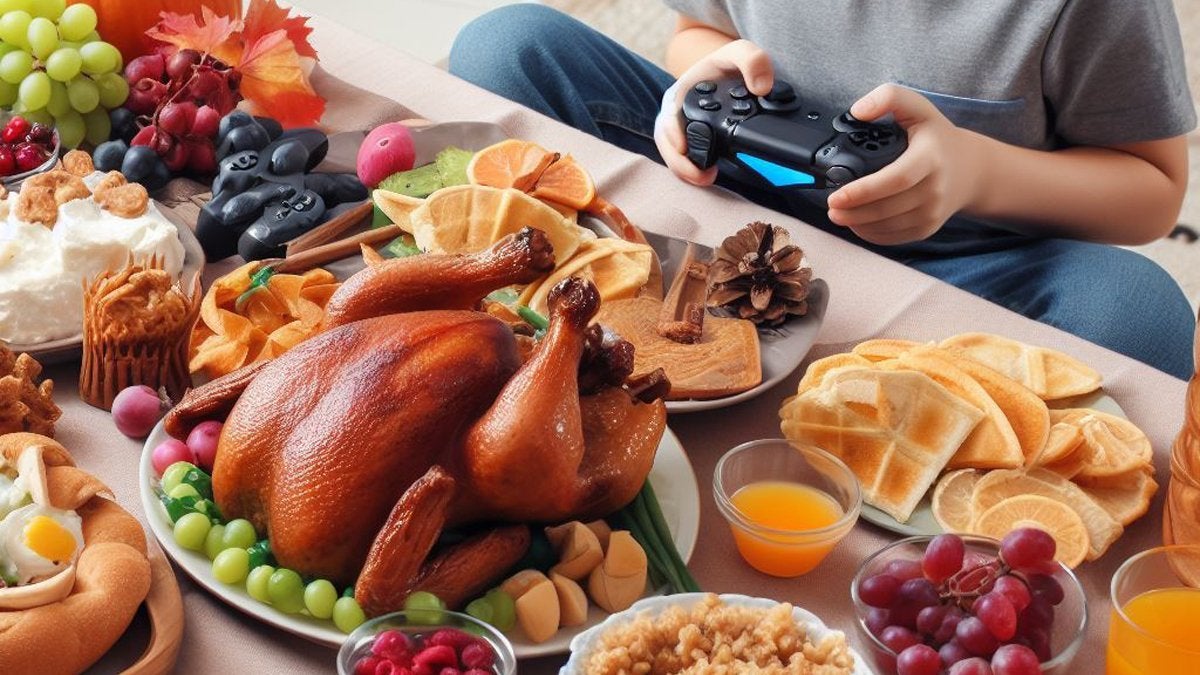 A child holding a gaming controller while sitting in front of a table covered with traditional Thanksgiving foods.