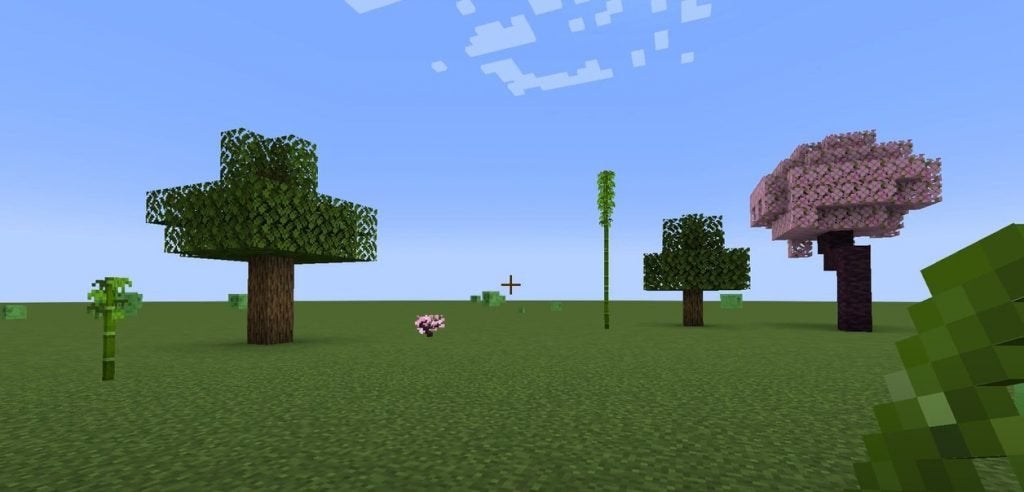 A player is planting bamboo and a few different types of trees in a flat world within Minecraft. The random growth rates of plants is a mechanic typical in emergent gameplay.